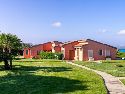 Case arancioni immerse nel verde, vista mare e cielo sereno.