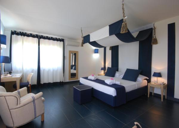 Camera elegante con letto matrimoniale e decorazioni blu e bianche.