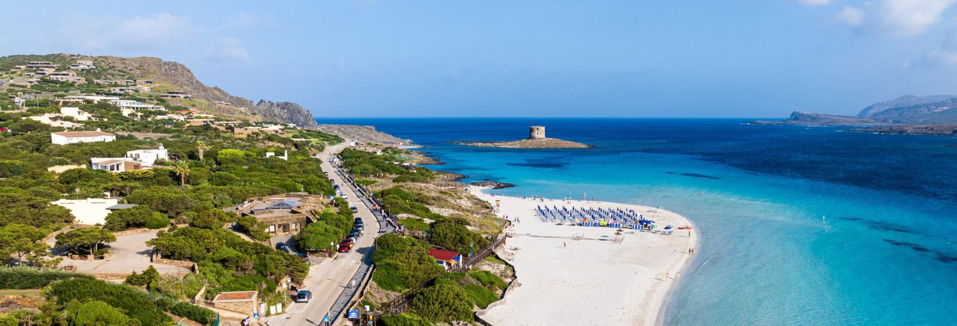 Spiaggia bianca, mare turchese, torre antica, natura rigogliosa, bellezza mozzafiato.
